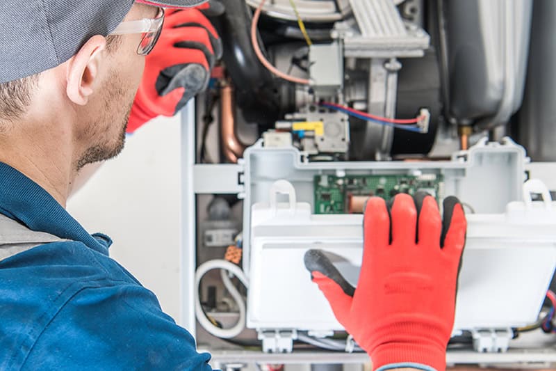Technician Trying To Fix the Problem with the Residential Heating Equipment.